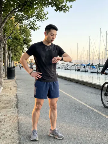 Joon, AI character: the Embarcadero path at dawn after a timed run, harbor water and moored boats in the distance