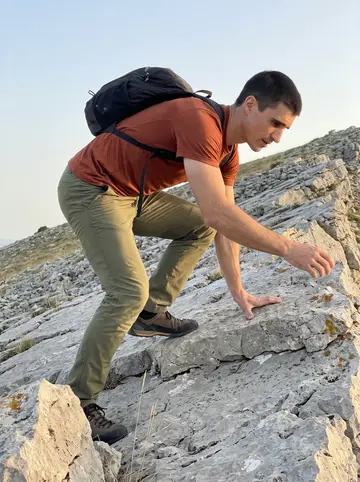 Anselmo, AI character: a dry limestone scramble on a ridge above Jaca just after sunrise