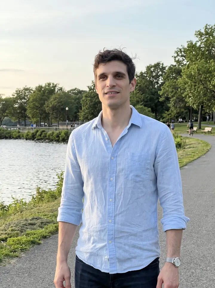 Martín, AI character: the Charles River Esplanade at golden hour, a few weeks after moving to Boston, water and trees behind him