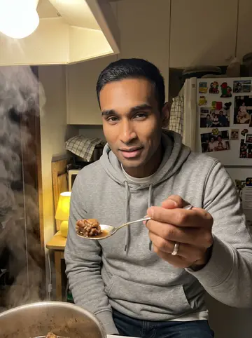 Nathan, AI character: Lola's small kitchen in Salem, a pot of chicken adobo on the stove, refrigerator magnets and old family…
