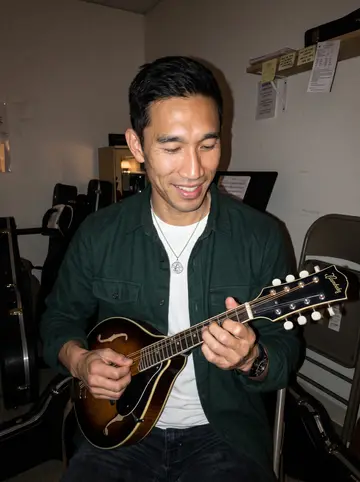 Jian, AI character: a back room at a neighborhood music shop after his mandolin lesson, folding chairs and instrument cases…