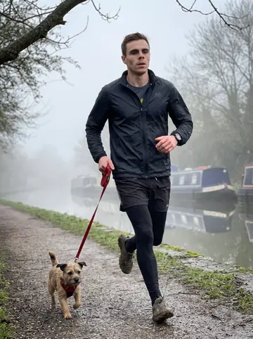 Callum, AI character: the Leeds-Liverpool canal towpath just after dawn, damp path, narrowboats soft in the background