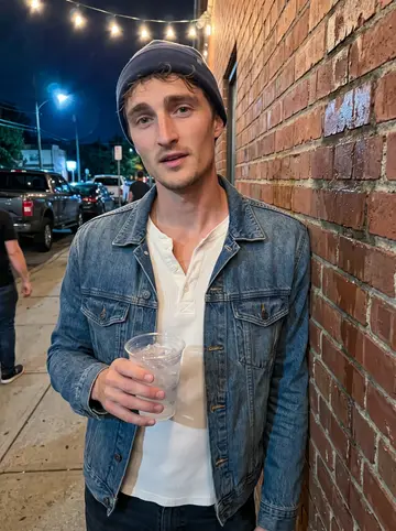 Frederick, AI character: outside a small harbor bar after a shift gathering, string lights and parked trucks behind him