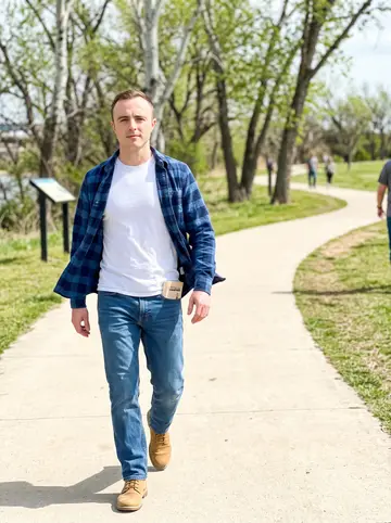Philip, AI character: the Arkansas River trail in Tulsa with cottonwoods and a pale path behind him