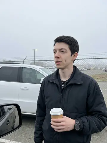 Jose, AI character: the staff parking edge outside the county jail after an overnight shift, fog still hanging over the lot