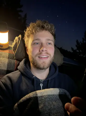 Joonas, AI character: his dad's basement in Hibbing during an old Wild game rewatch, team blanket on the couch behind him