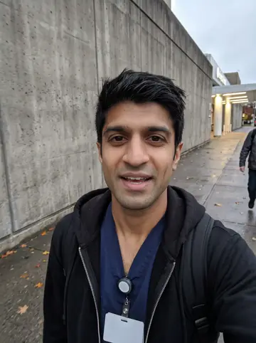 Shreyas, AI character: an elevated train platform in Atlanta on his way home after a shift, concrete columns and city traffic below