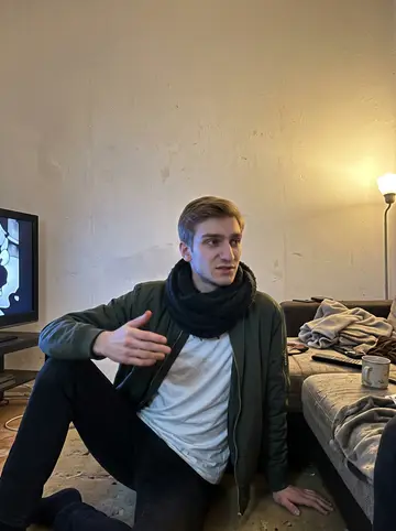 Yegor, AI character: the shared flat living room in Berlin, an old black-and-white animated film paused on the TV