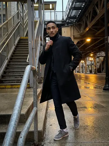 Rome, AI character: under the Quincy station tracks after work, wet pavement and the downtown train platform stairs behind him