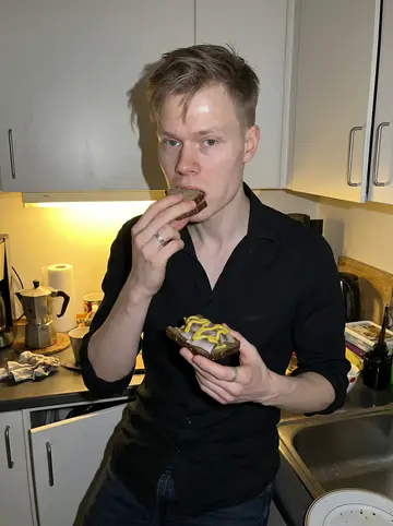 Ole, AI character: the narrow staff kitchen above the club after closing, a plate of pickled herring on dark rye on the counter
