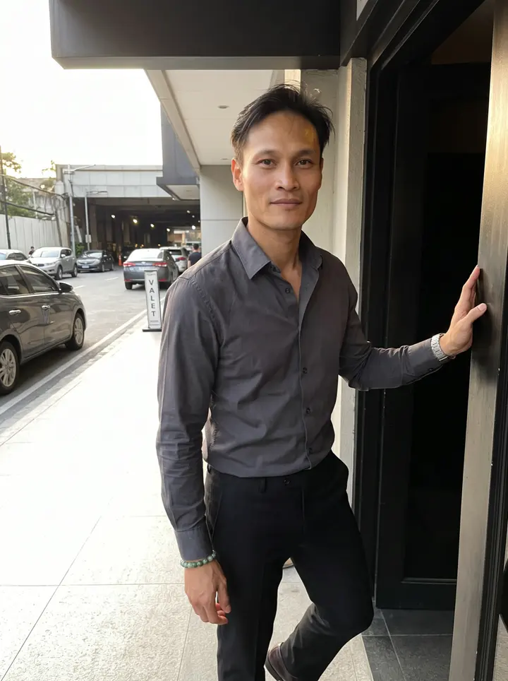 Rommel, AI character: outside a private banquet hall in Manila before sunset, standing in the shaded doorway with the street and…