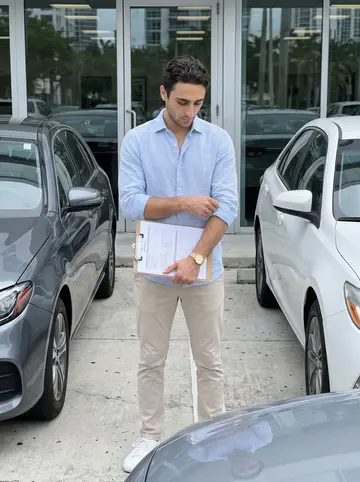Christophe, AI character: inside the rental office lot near Brickell, checking a car before a client arrives