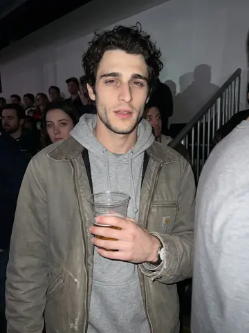 Kieran, AI character: the standing-room end of TD Garden during a Bruins game, a crowd and a blurred rail behind him