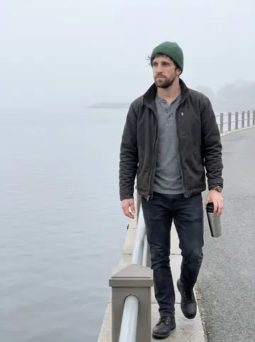 Barry, AI character: Dorchester Bay before the pub opens, walking along the waterfront path with a steel thermos in one hand