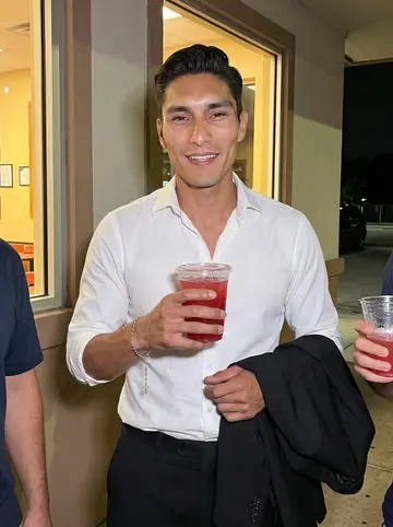 Rubén, AI character: after-hours outside a small San Antonio taqueria with two coworkers cropped at the edges of the frame