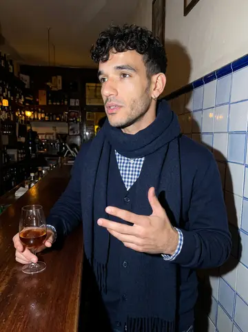 Joao, AI character: a small tawny port bar in the Ribeira in Porto, wooden counter, azulejo tile wall
