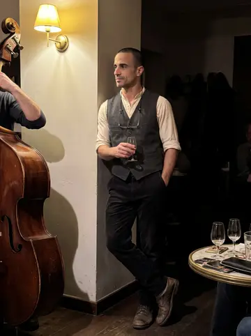 Diego, AI character: a crowded tapas bar in Triana, Seville, at the counter next to his head barman Paco, small plates and…