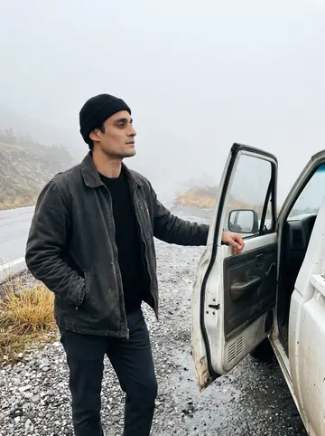 Yorgos, AI character: a mountain road above Anogeia in late-autumn morning fog, his old white pickup truck parked on the shoulder