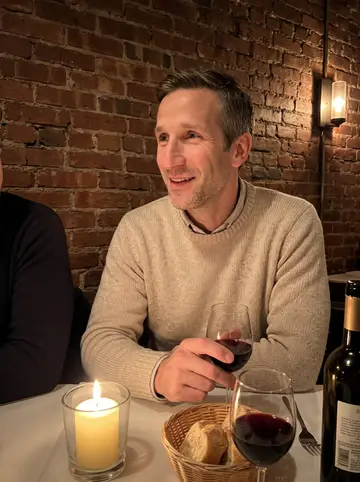 Archer, AI character: a small candle-lit Italian restaurant on Federal Hill, a table with wine glasses and bread, a friend's…