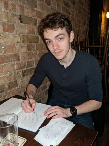 Edward, AI character: a back table at the family bar after closing, brick wall and stacked chairs behind him