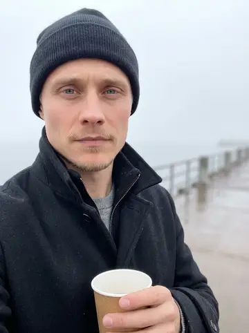 Arttu, AI character: on the Duluth harbor walk before opening the alley, fog over Lake Superior behind him