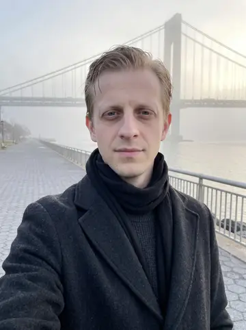 Torstein, AI character: the Verrazzano promenade at dawn, fog softening the bridge cables behind him