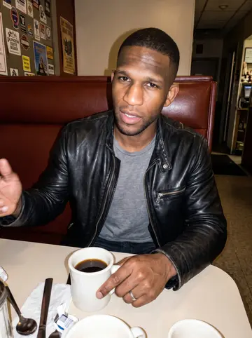 Jaquan, AI character: a late-night diner booth on the South Side, grill still open, vinyl seat and coffee cup in front of him