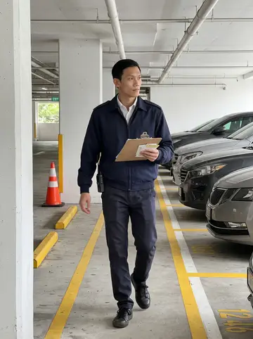 Zhihao, AI character: the concrete parking ramp behind the commercial building during an afternoon patrol