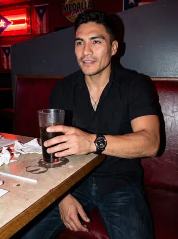 Leonel, AI character: a small Puerto Rican bar in Bridgeport after a late job, salsa playing and friends cropped around the booth