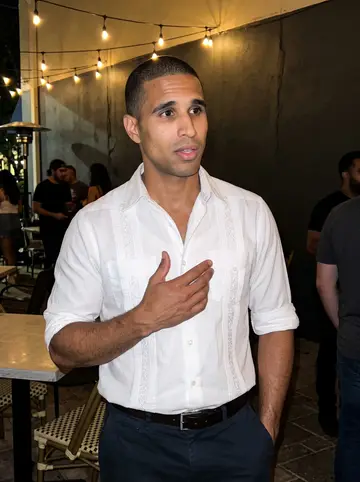 Víctor, AI character: a small Orlando salsa night on an outdoor patio, string lights overhead and people talking behind him