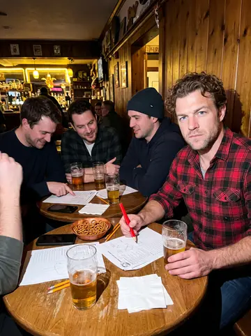 Rhett, AI character: inside the town bar on Friday trivia night, a wood-panelled wall with a scrawled chalkboard of questions…