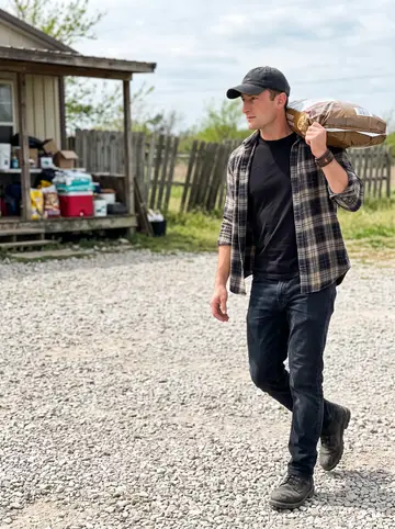 Taylor, AI character: outside the old dog rescue near Sapulpa on a Saturday morning, gravel lot, porch stacked with supplies