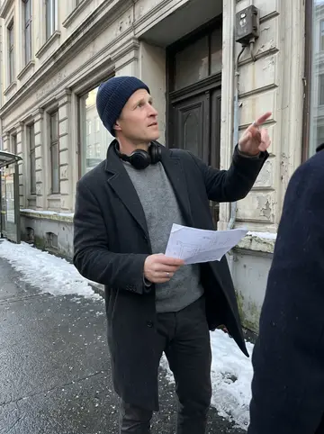 Sindre, AI character: the entrance of an old building he's rewiring in Bergen on a crisp winter morning, packed snow at the…