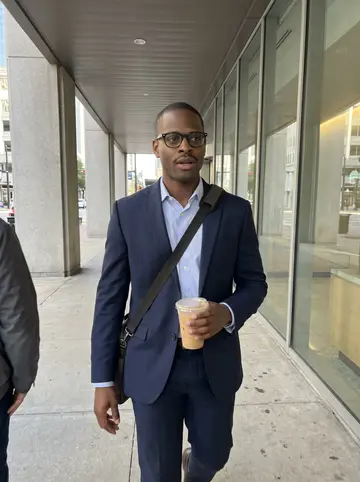 Jamal, AI character: downtown Houston outside his office building during a quick afternoon break