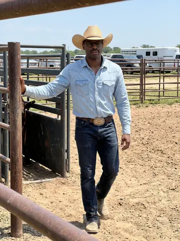 Jamal, AI character: a dusty practice arena near Hempstead, with a horse rail and steer chute in the background