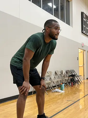 Chukwuemeka, AI character: Alief rec center basketball court after Thursday pickup, glossy wood floor and folding chairs along the wall