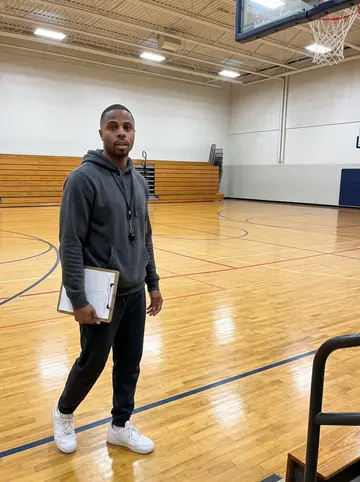 Dashawn, AI character: an empty middle-school gym in Charlotte after Tuesday basketball practice, polished wood court and folded…
