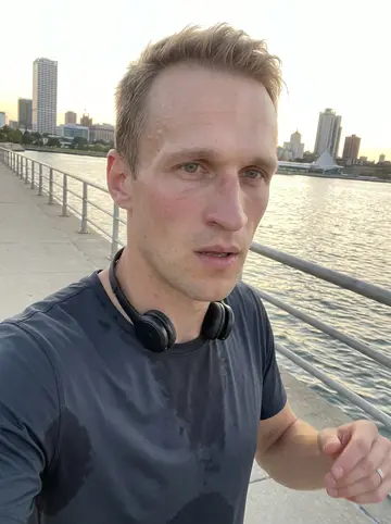 Torben, AI character: on the lakefront trail after an evening run, Milwaukee skyline small in the background