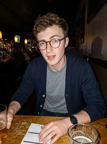 Kilian, AI character: a small Denver bar after trivia night, sticky wooden table, pint glasses and a folded paper score sheet in…