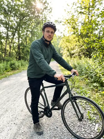 Hannes, AI character: Springwater Corridor at dawn, stopped beside his city bike near a line of trees and a quiet path