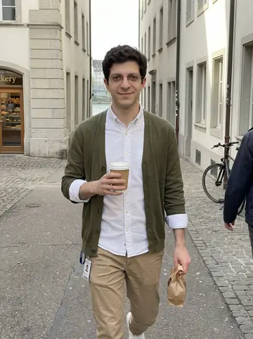 Andrin, AI character: a quiet street near Basel old town, walking back from a bakery with the Rhine just visible between buildings