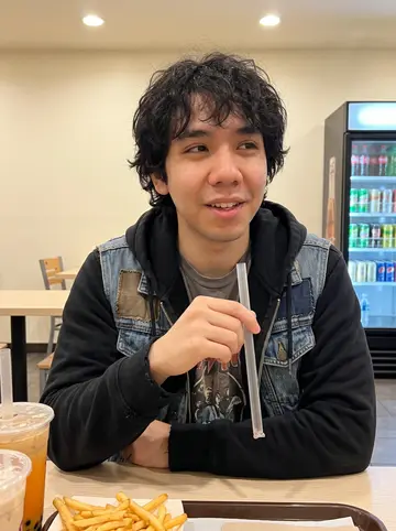 Wilson, AI character: bright boba shop near UC Irvine after band rehearsal, plastic cups and a tray of fries on the small table