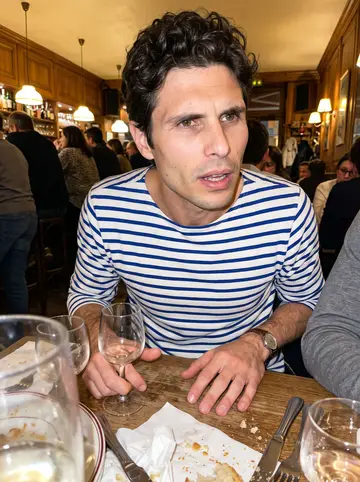 Étienne, AI character: a small Lyon bouchon at a crowded table after dinner, warm wood paneling and half-empty glasses behind him