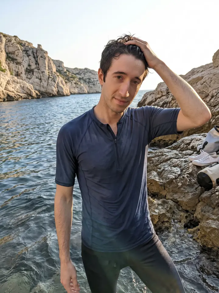 Titouan, AI character: the shallow edge of the Calanques outside Marseille at dawn after free-diving with Yanis, pale limestone…