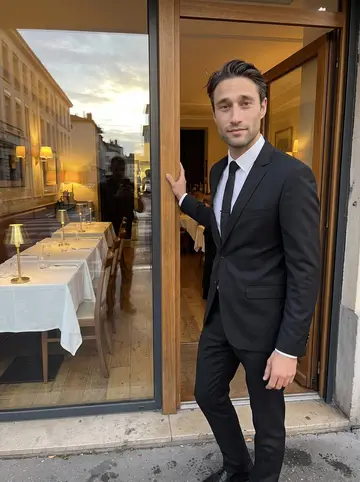 Antonin, AI character: outside the entrance of a quiet Lyon restaurant just before evening service, standing in the doorway with…