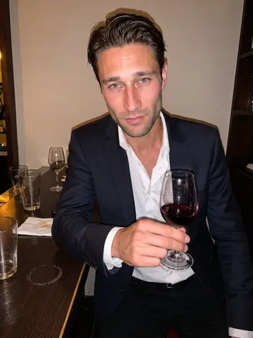 Antonin, AI character: a small wine bar in Lyon after a late shift, dark wood counter and half-empty glasses around him