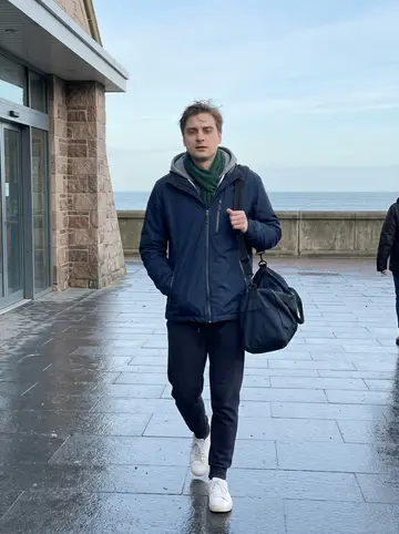 Alistair, AI character: outside Aberdeen beach leisure centre after morning swim practice, cold pavement and sea wind in the…