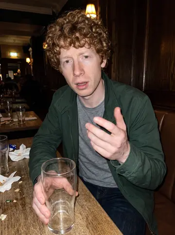 Douglas, AI character: a crowded Edinburgh pub after a winter league night, dark wood wall and half-empty pint glasses on the table