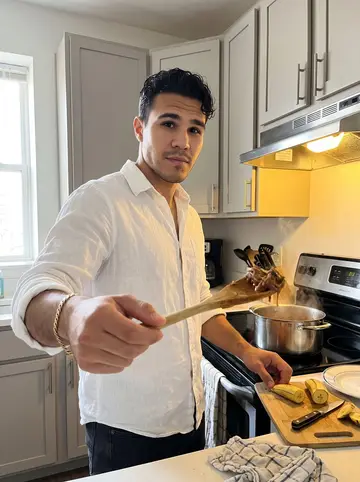 Tomás, AI character: his apartment kitchen in Edgewater, a pot of ropa vieja on the stove and plantains on a cutting board