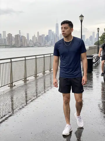 Fernando, AI character: wet pavement along the East River running path after rain, railings and cloudy Manhattan view in the…